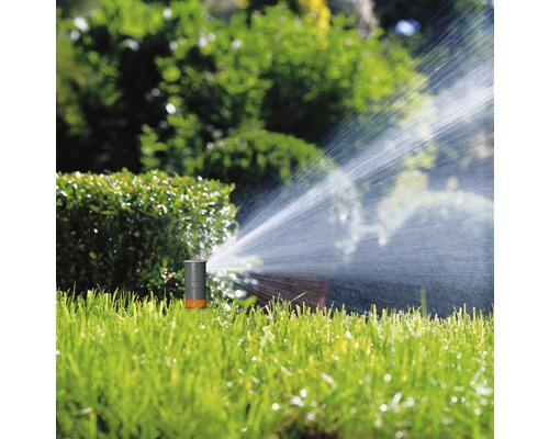 Arroseur de gazon arrosant la pelouse dans le jardin.