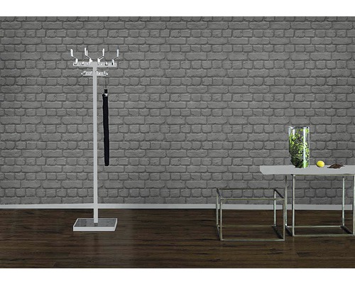 Hall d''entrée avec porte-manteau, parapluie et table avec décoration devant un mur de briques