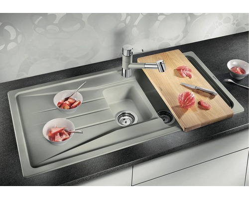 Spüle mit Abtropffläche, Armatur und Schneidebrett auf einer Küchentheke