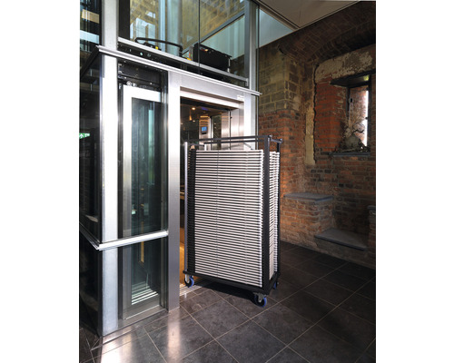 Ein Aufzug mit einem Wagen voller Platten in einem Gebäude.