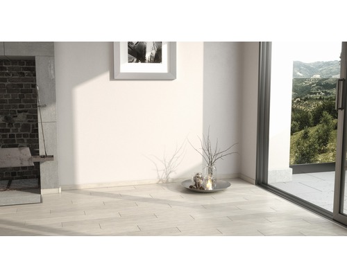 Heller Raum mit Kamin, Kunstwerk und Terrassentür mit Blick ins Grüne.