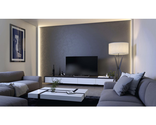 Wohnzimmer mit Sofa, Couchtisch, Fernseher und Stehlampe