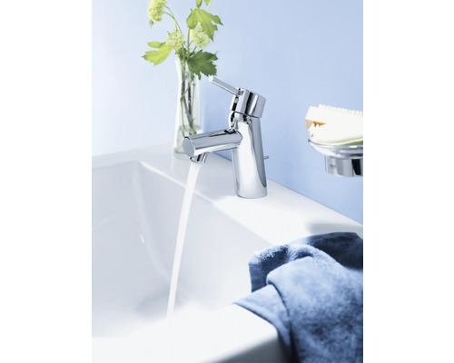 Mitigeur de lavabo chromé avec eau courante dans une salle de bain