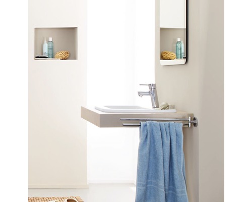 Salle de bain lumineuse avec lavabo, robinet et porte-serviettes