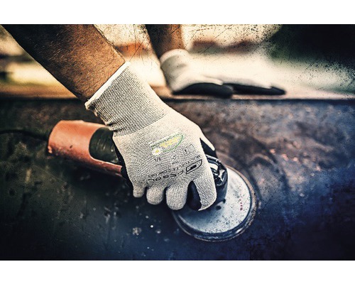 Eine Person, die mit einem Winkelschleifer arbeitet und dabei Schutzhandschuhe trägt