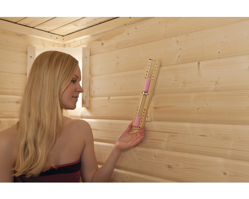 Femme dans un sauna avec sablier pour mesurer le temps