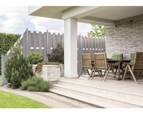 Terrasse mit Holzzaun, Steintisch und Stühlen