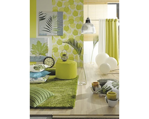 Helle Raumgestaltung mit grünen Textilien, Teppich, Kissen und Wandbildern mit Pflanzenmotiven