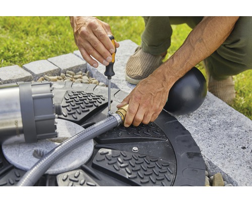 Installation einer Gartenpumpe mit Schraubenzieher und Schlauchanschluss