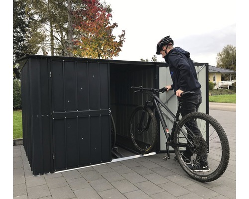 Garage à vélos avec une personne rangeant un vélo.