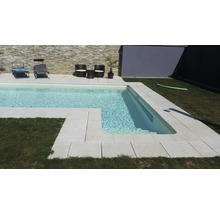Swimmingpool mit hellen Steinfliesen und Gartenmöbeln