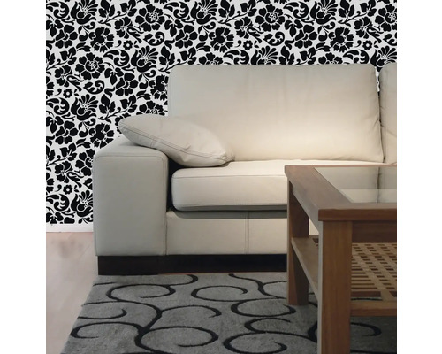 Salon avec canapé, table en bois, tapis à motifs et papier peint floral