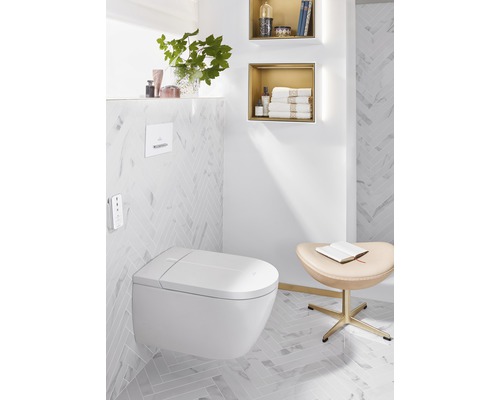 Helles Badezimmer mit wandhängendem Dusch-WC, Ablagen und Hocker.