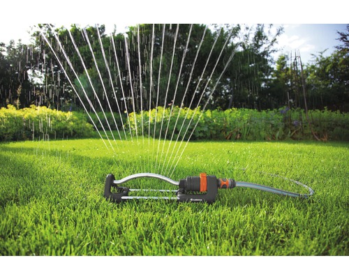 Arroseur Gardena sur une pelouse verte dans le jardin.