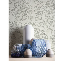 Vases décoratifs de différentes formes et papier peint à motifs floraux en arrière-plan