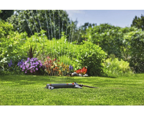 Arroseur de pelouse en marche sur une pelouse verte