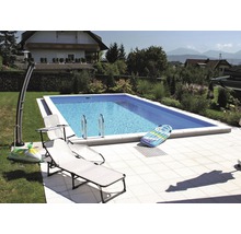 Piscine rectangulaire dans le jardin avec chaises longues et jouets gonflables