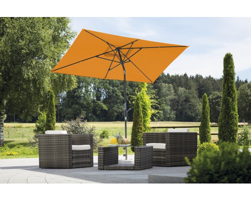 Gartenszene mit rechteckigem Sonnenschirm, Rattansesseln und Tisch im Freien.