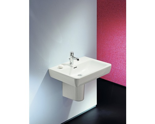 Lavabo blanc avec robinet et savon monté sur un mur