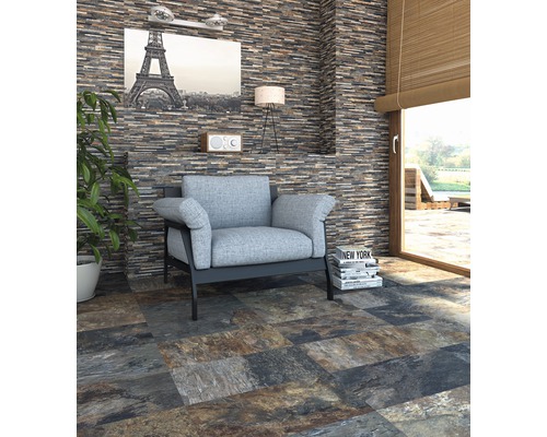 Salon avec mur en pierre naturelle et carrelage au sol imitation pierre, fauteuil et décoration