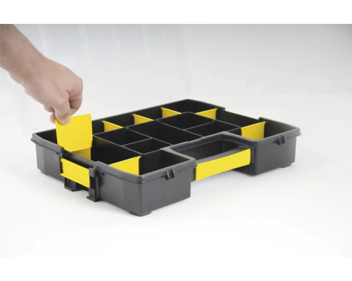 Boîte de rangement noire avec inserts jaunes et une main insérant un insert