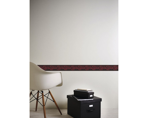 Wand mit Bordüre mit Rosenmuster, Stuhl und Aufbewahrungsboxen