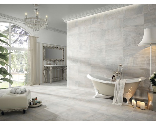 Helles Badezimmer mit freistehender Badewanne, Fliesenboden und Kristalllüster