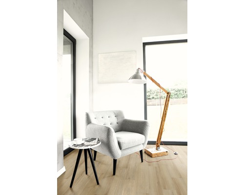 Salon lumineux avec fauteuil, lampadaire et petite table sur parquet