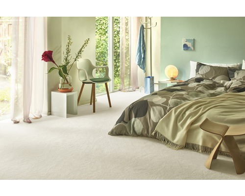 Chambre lumineuse avec lit, chaise, fenêtre et moquette