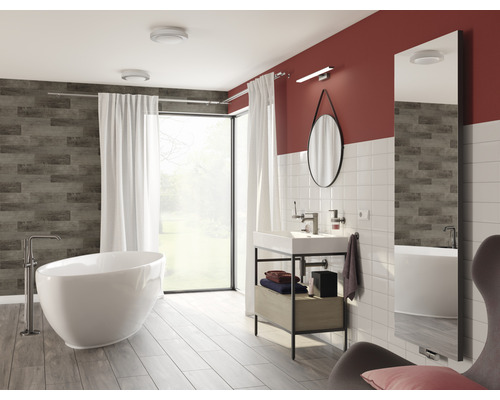 Salle de bain lumineuse avec baignoire, lavabo et miroir