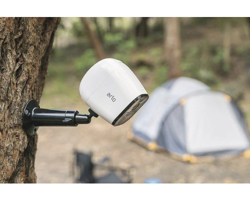 Caméra de surveillance Arlo fixée à un arbre, avec tente en arrière-plan