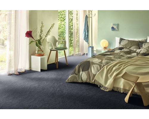 Chambre à coucher avec lit, chaise et moquette foncée.
