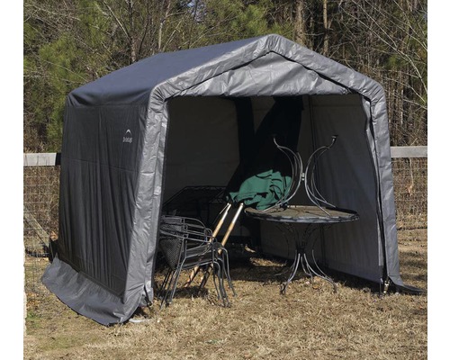 Graues Gerätehaus mit Gartentisch und Stühlen im Inneren