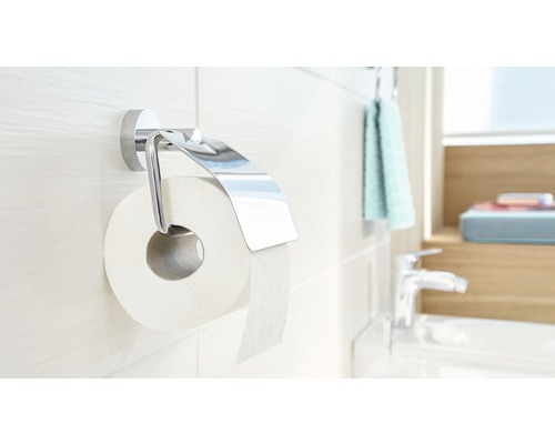 Porte-papier toilette chromé avec rouleau de papier sur un mur de salle de bain