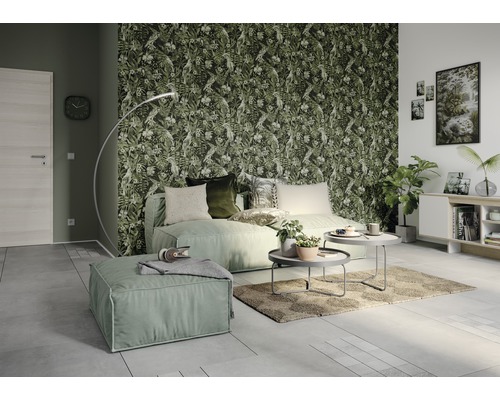 Wohnzimmer mit Sofa, Ottomanen, Couchtischen, Stehlampe, Zimmerpflanzen und Dschungeltapete