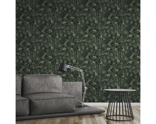 Wohnzimmer mit grauer Couch, Stehlampe und gemusterter Tapete mit Blättern und Papageien