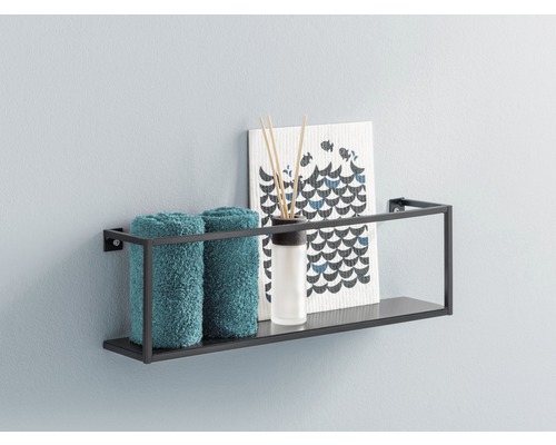 Étagère murale avec serviettes, bâtonnets parfumés et décoration sur un mur