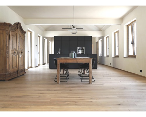 Helles Wohnzimmer mit Holzboden, Esstisch, Stühlen und Küchenzeile