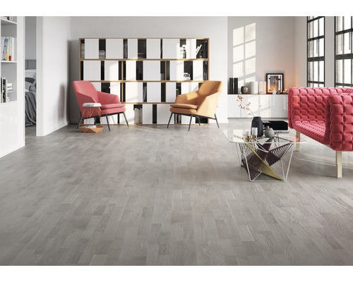 Salon avec plancher en bois clair, fauteuils et étagère