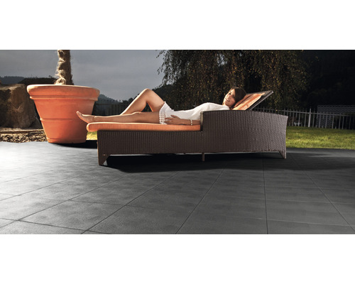 Terrasse mit Fliesen, Liege und Pflanzgefäß im Garten