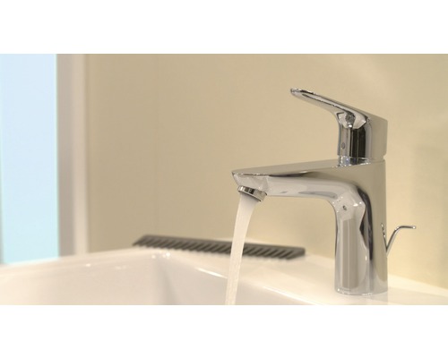 Wasserhahn aus Metall mit Wasserstrahl im Badezimmer