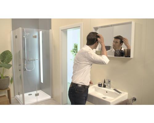 Badezimmer mit Dusche, Waschbecken und Spiegel