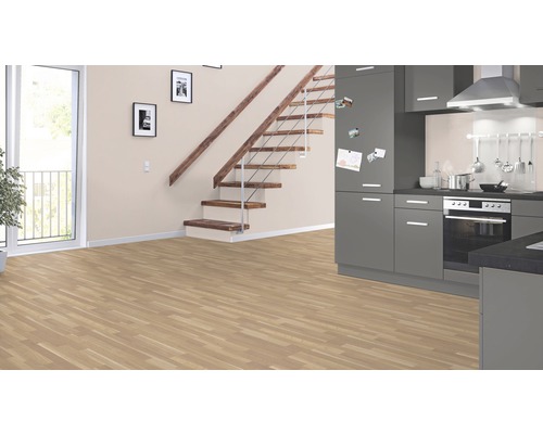 Pièce claire avec sol stratifié, escalier et kitchenette