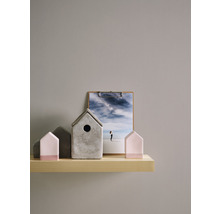Dekorative Hausmodelle aus Beton und Holz auf einem Regal mit einem Bild