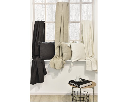 Coussins décoratifs et jetés sur un rebord de fenêtre à côté d''une table d''appoint avec livre et tasse