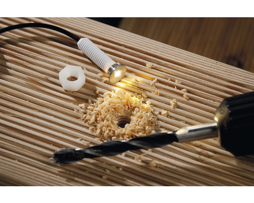 Installation d''une lampe LED dans une terrasse en bois avec une perceuse