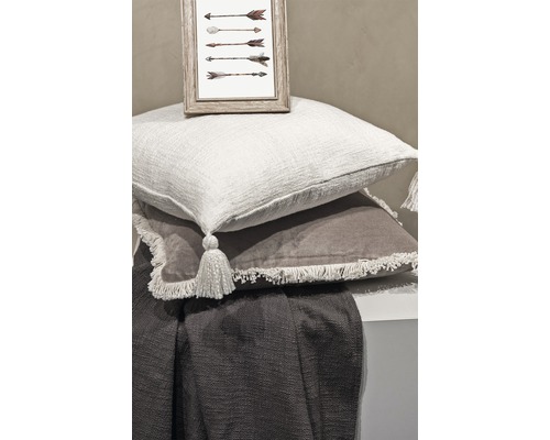 Dekorative Anordnung mit Kissen, Decke und gerahmtem Bild