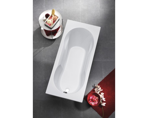Baignoire rectangulaire dans salle de bains avec accessoires de bain