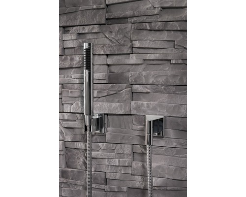 Handbrause mit Brauseschlauch vor Steinwand