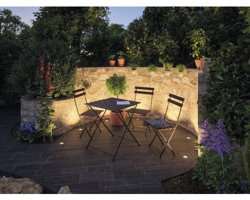 Jardin avec terrasse en pierre, mur en pierre, table, chaises et plantes
